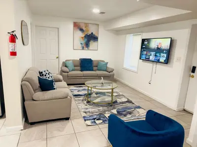 a living room with two couches and a tv at Cosy Bedroom 6 minutes to EWR Prudential Hotels Pen station in Newark