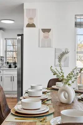 a dining room table with plates and a vase at NYC 20min, Sleeps 10, Free Parking, Patio in Bayonne