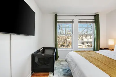 a bedroom with a bed and a flat screen tv at NYC 20min, Sleeps 10, Free Parking, Patio in Bayonne