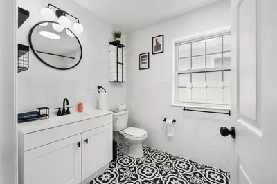 a bathroom with a toilet and a sink and a mirror at NYC 20min, Sleeps 10, Free Parking, Patio in Bayonne
