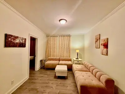a living room with a large couch and a table at Penn Station Room Motel Casa in Newark