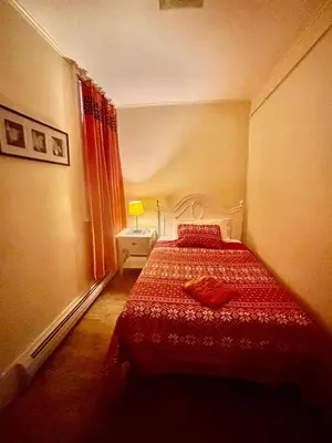 a bedroom with a bed with a red bedspread at Penn Station Room Motel Casa in Newark