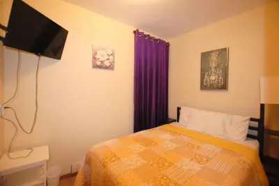 a bedroom with a bed and a flat screen tv at Penn Station Room Motel Casa in Newark