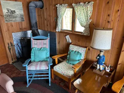 a living room with two chairs and a lamp at Rustic Lakefront Cabin in Starrucca
