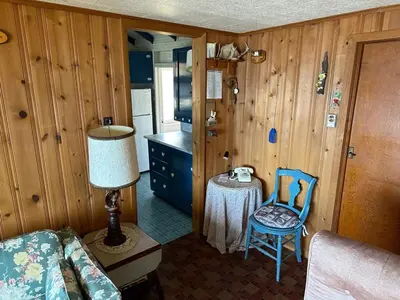 a small kitchen with a table and a chair in a room at Rustic Lakefront Cabin in Starrucca