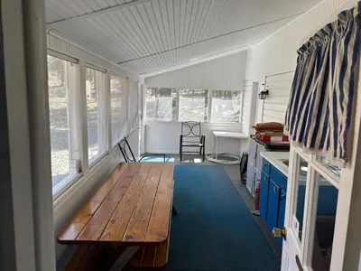 a room with a wooden bench in a tiny house at Rustic Lakefront Cabin in Starrucca