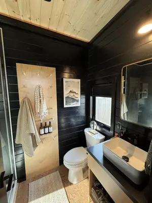 a black bathroom with a toilet and a sink at The Retreat on the Ranch (INSANE VIEW) in Gap