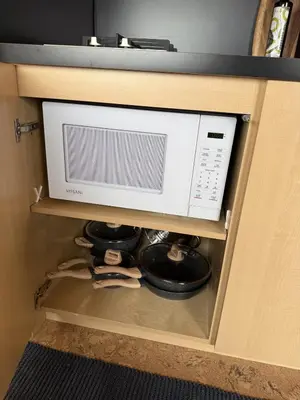 a microwave oven in a cabinet with a shelf at The Retreat on the Ranch (INSANE VIEW) in Gap