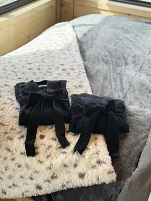 two bows are sitting on a blanket on a bed at The Retreat on the Ranch (INSANE VIEW) in Gap