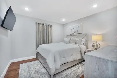 a white bedroom with a bed and a television at Your home away from home in Newark