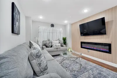 a living room with a couch and a fireplace at Your home away from home in Newark
