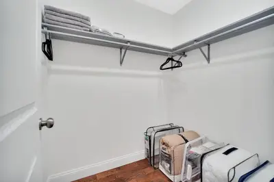 a shelf in a room with luggage and towels at Your home away from home in Newark