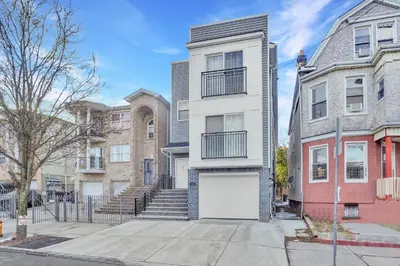 an apartment building with a white garage at Home away from home 2 in Newark