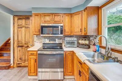 a kitchen with wooden cabinets and stainless steel appliances at Home 2 Mi to Thayer Gate at U S Military Academy in Highland Falls