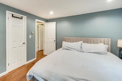 a bedroom with a bed and a blue wall at Home 2 Mi to Thayer Gate at U S Military Academy in Highland Falls