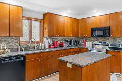 a kitchen with wooden cabinets and a counter top at Spacious Game Room Seclusion Hot Tub and more in Long Pond