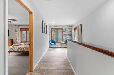 a hallway leading to a bedroom with a bed at Spacious Game Room Seclusion Hot Tub and more in Long Pond