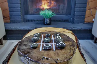 a wooden table with a fireplace in a living room at 3BR Home w Outdoor Fun Lake Fire Pit Games Grill in Tobyhanna
