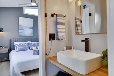 a bathroom with a white sink and a bed at 3BR Home w Outdoor Fun Lake Fire Pit Games Grill in Tobyhanna