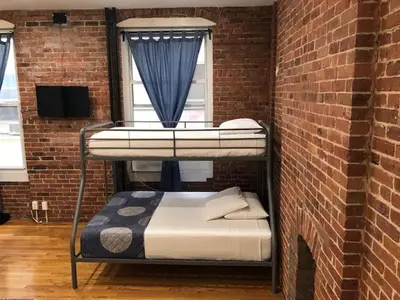 a room with two bunk beds in a brick wall at Studios Midtown Manhattan in New York