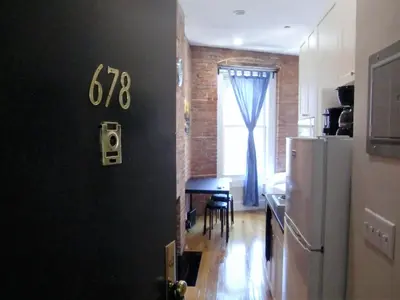 a kitchen with a black wall and a refrigerator at Studios Midtown Manhattan in New York