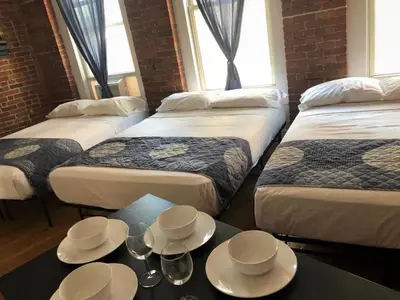 a room with four beds with bowls and cups on a table at Studios Midtown Manhattan in New York