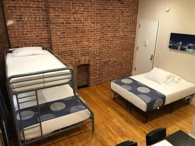 two bunk beds in a room with a brick wall at Studios Midtown Manhattan in New York