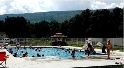 a group of people in a swimming pool at Rustic Cabin Rental on Family-Friendly Campsite near Harrisburg, Pennsylvania in Millmont