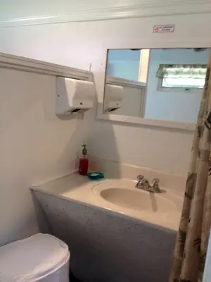 a bathroom with a sink and a mirror and a toilet at Rustic Cabin Rental on Family-Friendly Campsite near Harrisburg, Pennsylvania in Millmont