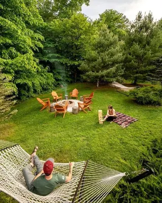 two people laying on a hammock in a yard at Incredible New York Cabin with a Spa and Movie Theater in Livingston Manor