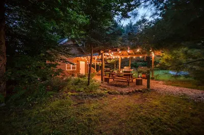 a wooden cabin with a picnic table under a tent at Incredible New York Cabin with a Spa and Movie Theater in Livingston Manor