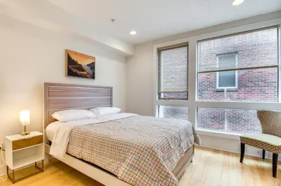a bedroom with a bed and two windows at 1 Mi to Old Town Philadelphia Townhome with Patio! in Philadelphia