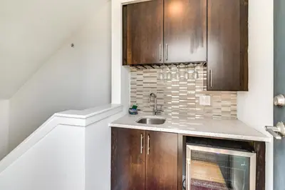 a kitchen with wooden cabinets and a sink at 1 Mi to Old Town Philadelphia Townhome with Patio! in Philadelphia