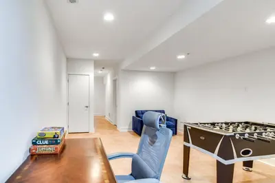 a living room with a table and a blue chair at 1 Mi to Old Town Philadelphia Townhome with Patio! in Philadelphia