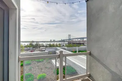 an open window with a view of a bridge at 1 Mi to Old Town Philadelphia Townhome with Patio! in Philadelphia