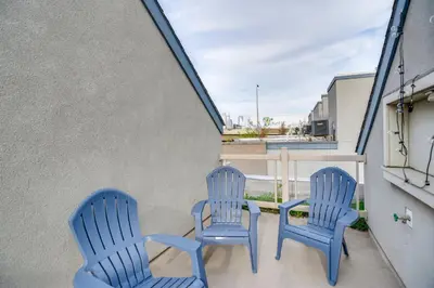 two blue chairs and a table on a balcony at 1 Mi to Old Town Philadelphia Townhome with Patio! in Philadelphia