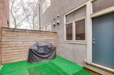 a fence with a tarp on it next to a building at 1 Mi to Old Town Philadelphia Townhome with Patio! in Philadelphia