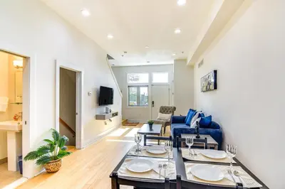 a living room with a blue couch and tables at 1 Mi to Old Town Philadelphia Townhome with Patio! in Philadelphia
