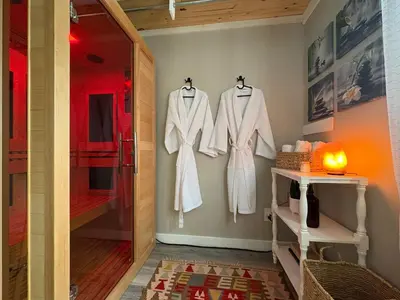 a dressing room with white coats hanging on a wall at Cabin with Sauna Close to Skiing in Arrowhead Lake