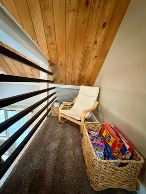 a room with a chair and books on a balcony at Cabin with Sauna Close to Skiing in Arrowhead Lake