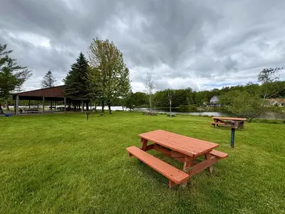 a picnic table and benches in a field at Cabin with Sauna Close to Skiing in Arrowhead Lake