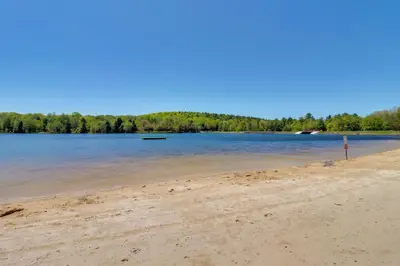 a beach with water and trees in the background at Beach Access BBQ-Ready Poconos Family Getaway! in Blakeslee