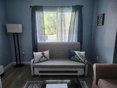 a living room with a couch and a window at Countryside Comfort in Willseyville