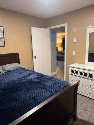 a bedroom with a bed and a dresser and a mirror at Countryside Comfort in Willseyville