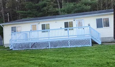 a large white house with a large deck at Countryside Comfort in Willseyville
