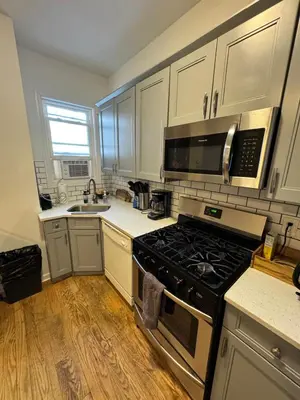 a kitchen with white cabinets and a stove top oven at 4 ROOMS FAMILY HOUSE WITH BACKYARD, LAUNDRY AND PARKINg in Union City