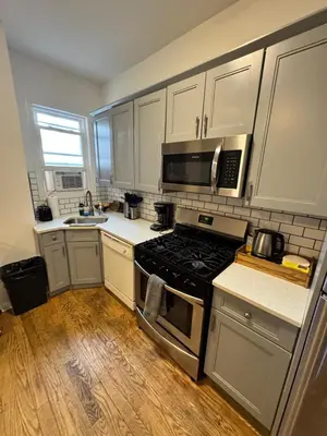 a kitchen with white cabinets and a stove top oven at 4 ROOMS FAMILY HOUSE WITH BACKYARD, LAUNDRY AND PARKINg in Union City