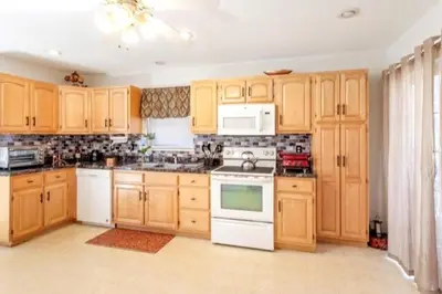 a kitchen with wooden cabinets and white appliances at Hilltop Villa in East Stroudsburg