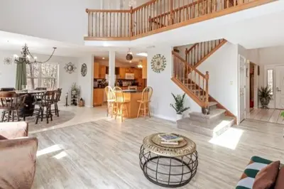 a living room with a staircase and a dining room at Hilltop Villa in East Stroudsburg