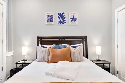 a bedroom with a large white bed with two lamps at Spacious Center City 3BR 4BA with Arcade - Sleeps 8 in Philadelphia